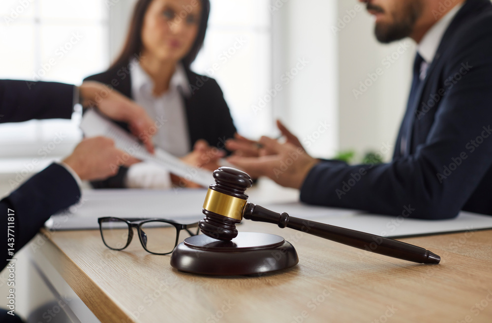 A group of lawyers sitting around a table with pieces of paper and a gavel on top of the table.