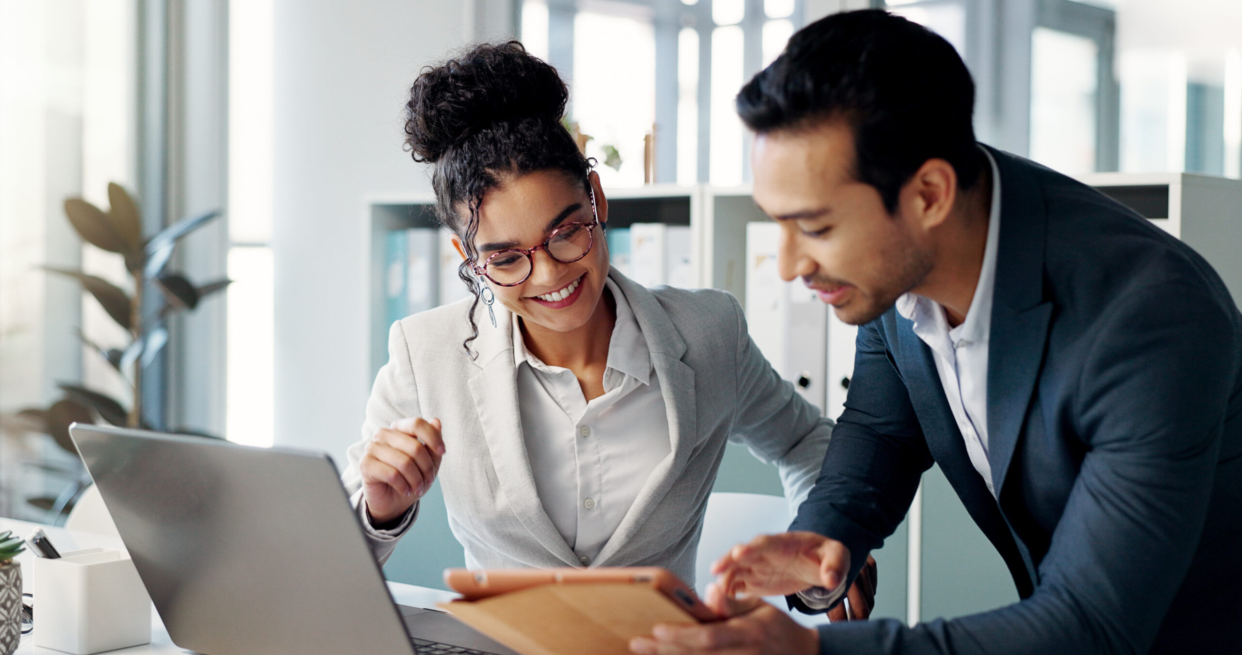 Two people in an office, both looking at a legal document.